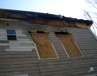Fire-damaged home after board up, before restoration